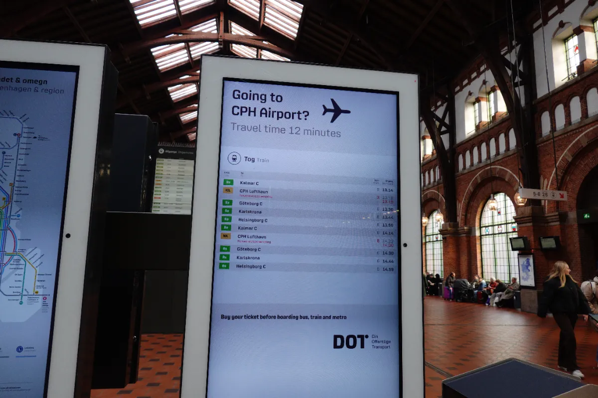 コペンハーゲン空港駅の運行案内板「Going to CPH Airport? Travel time 12 minutes」時刻表と各路線の表示 2026年撮影