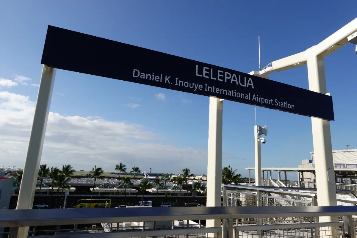 ダニエル K. イノウエ国際空港駅の駅名標「Daniel K. Inouye International Airport Station」とLELEPAUAの表示 2026年撮影